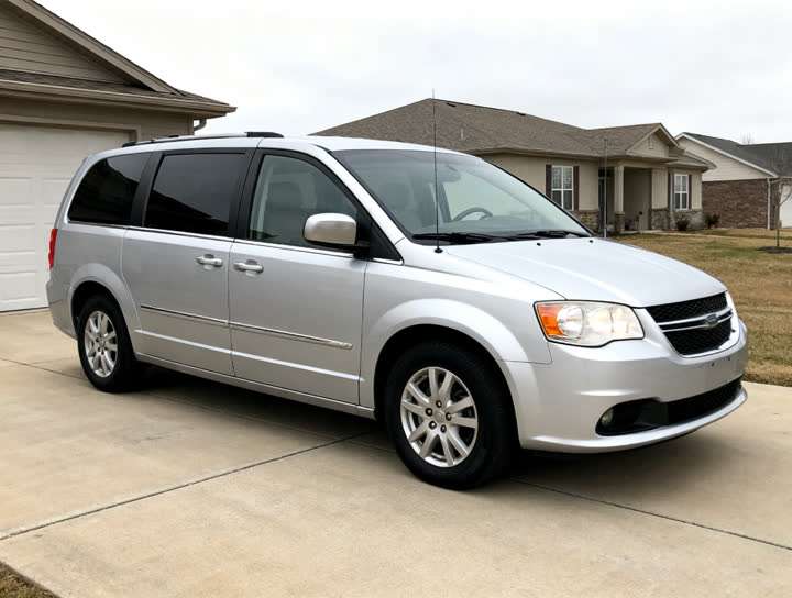 Input photo: a silver minivan parked in a driveway